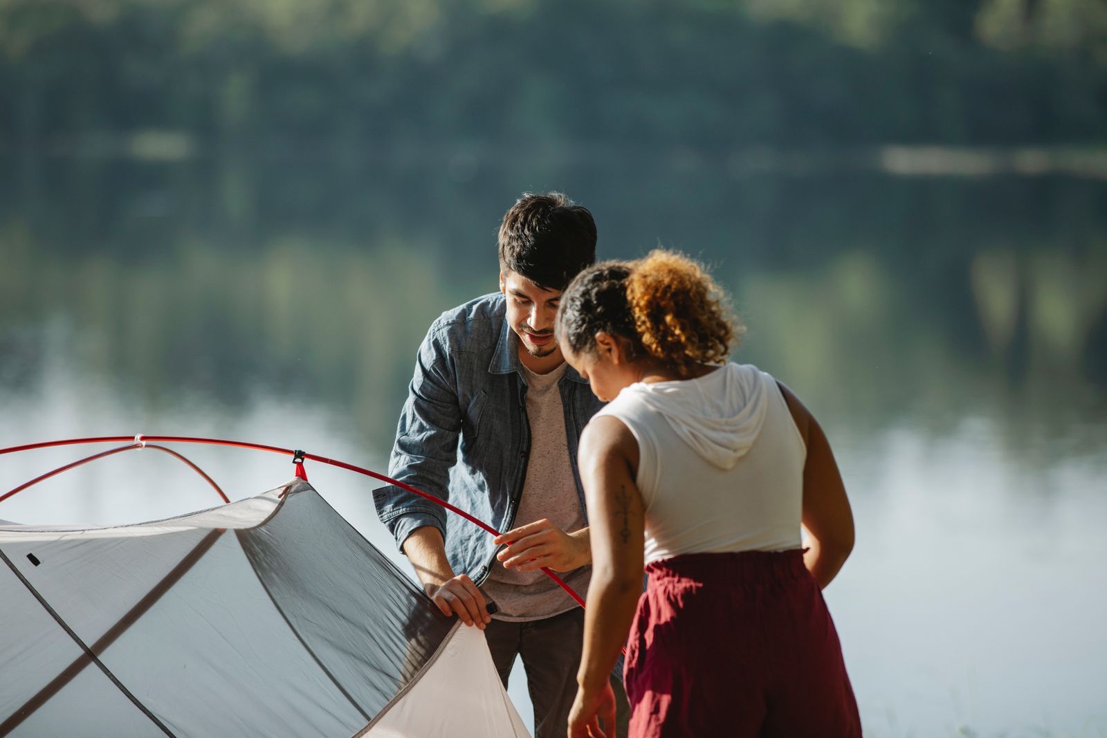 Teenagers jumping into a lake at camp